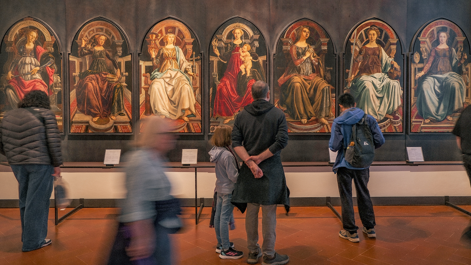 A group of people standing in front of a painting