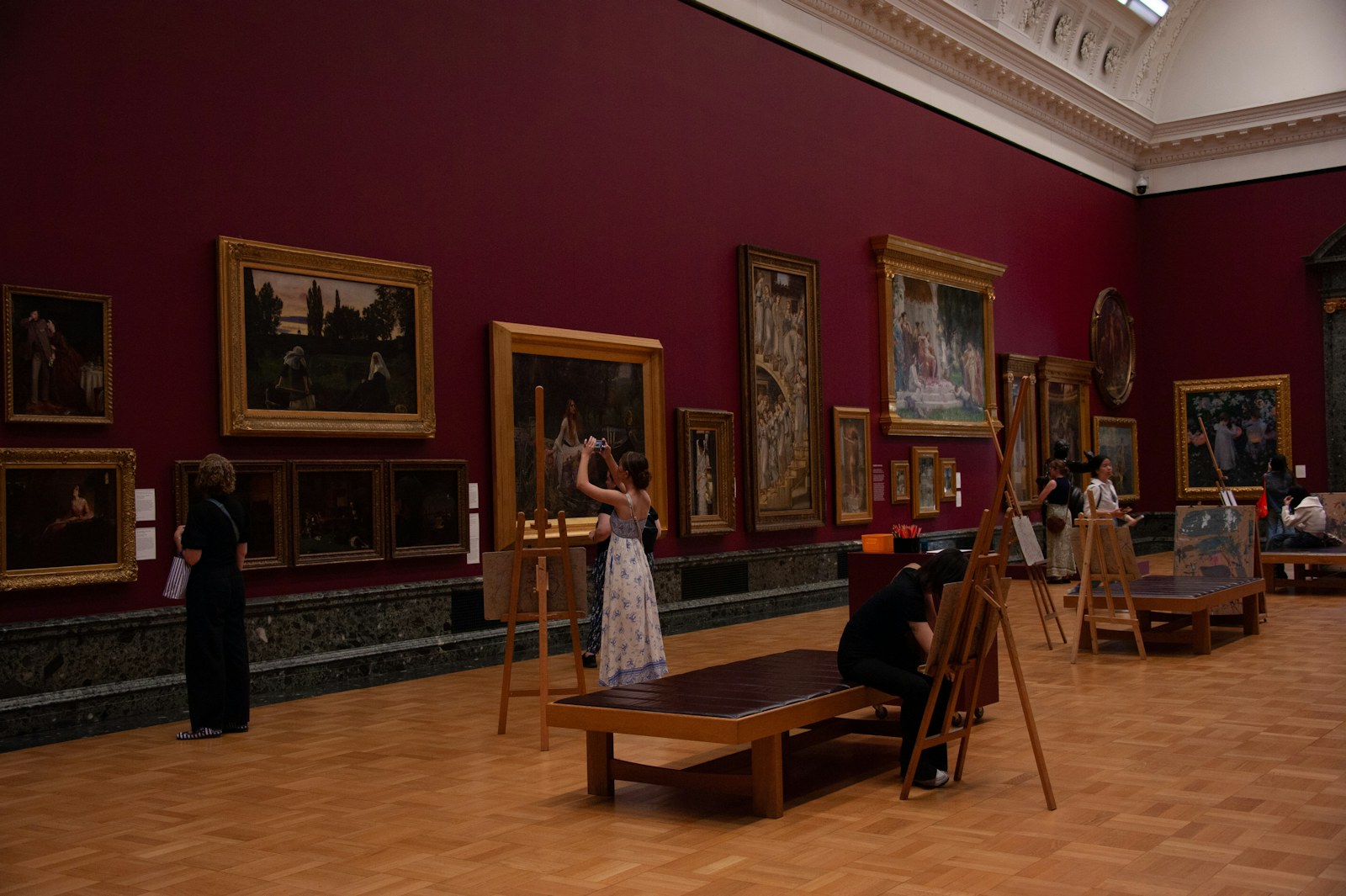People admire paintings in an art gallery