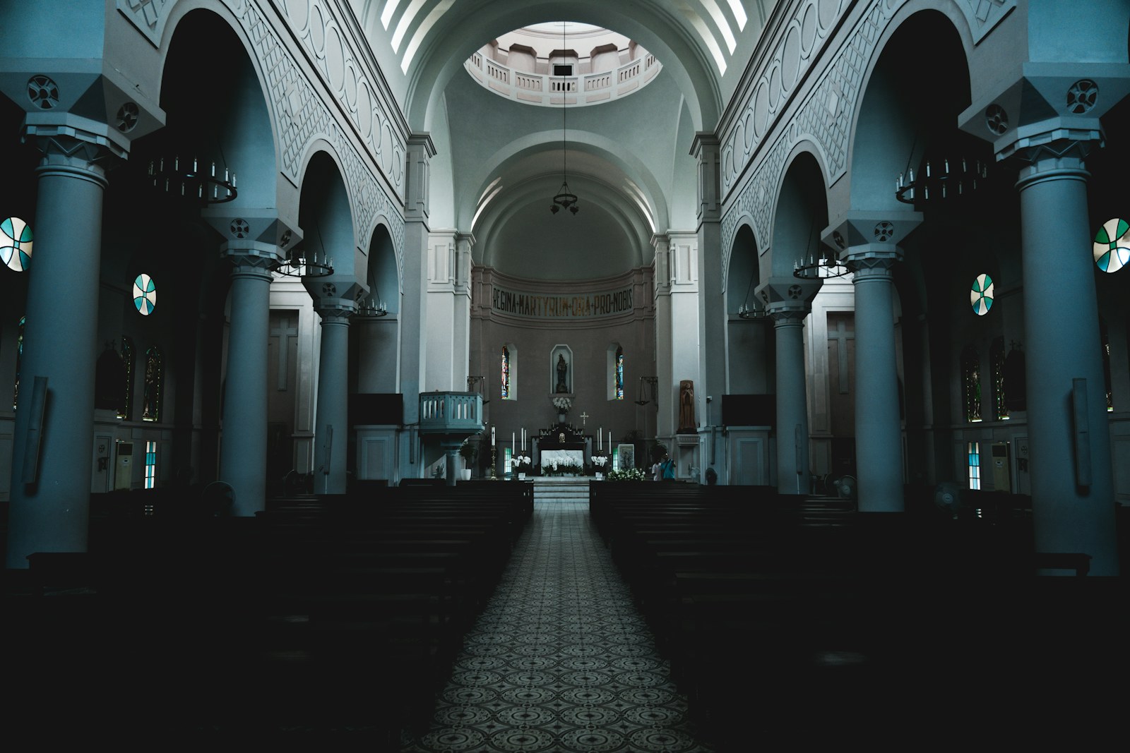 Interior of a grand, empty church with rows of seats