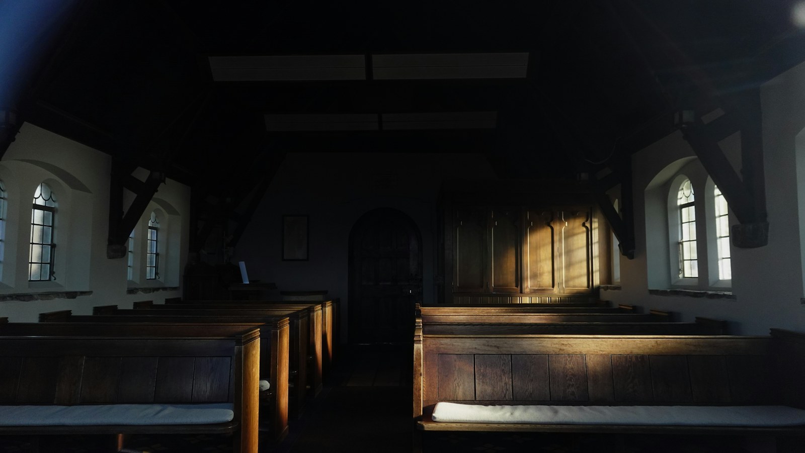 Empty church pews with sunlight streaming through windows