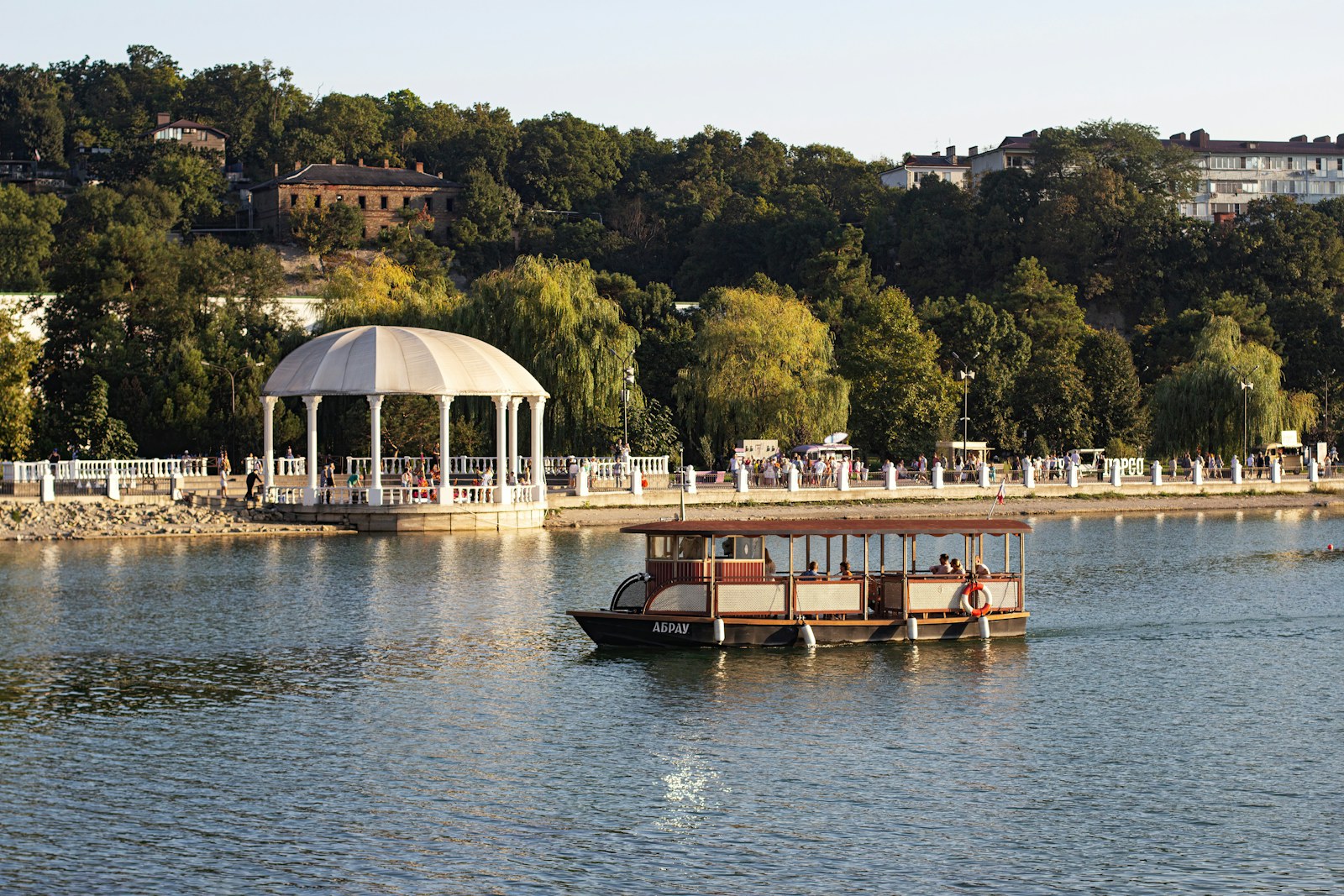 A boat floating on top of a lake next to a white gazebo