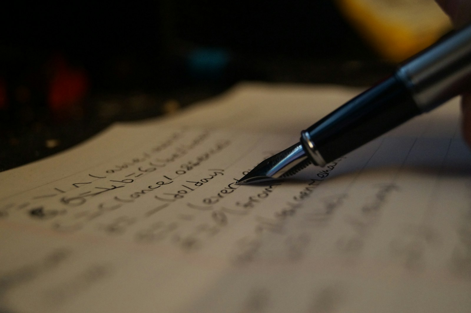 a person writing on a piece of paper with a pen
