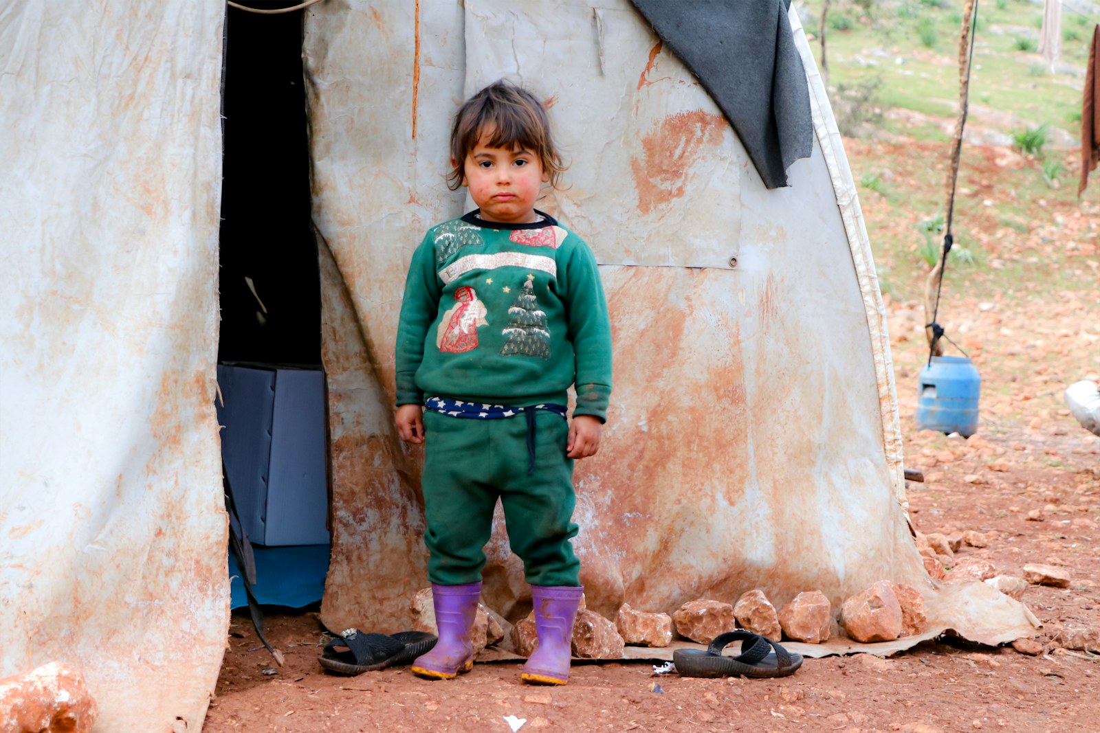A young child standing in front of a teepee