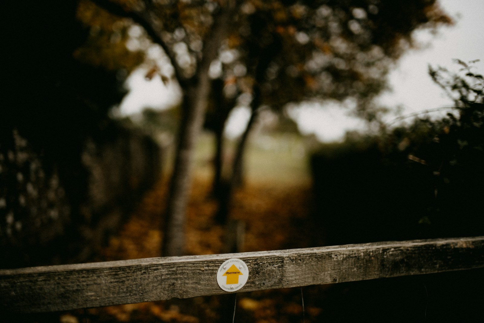 a wooden fence with a white and yellow sticker on it