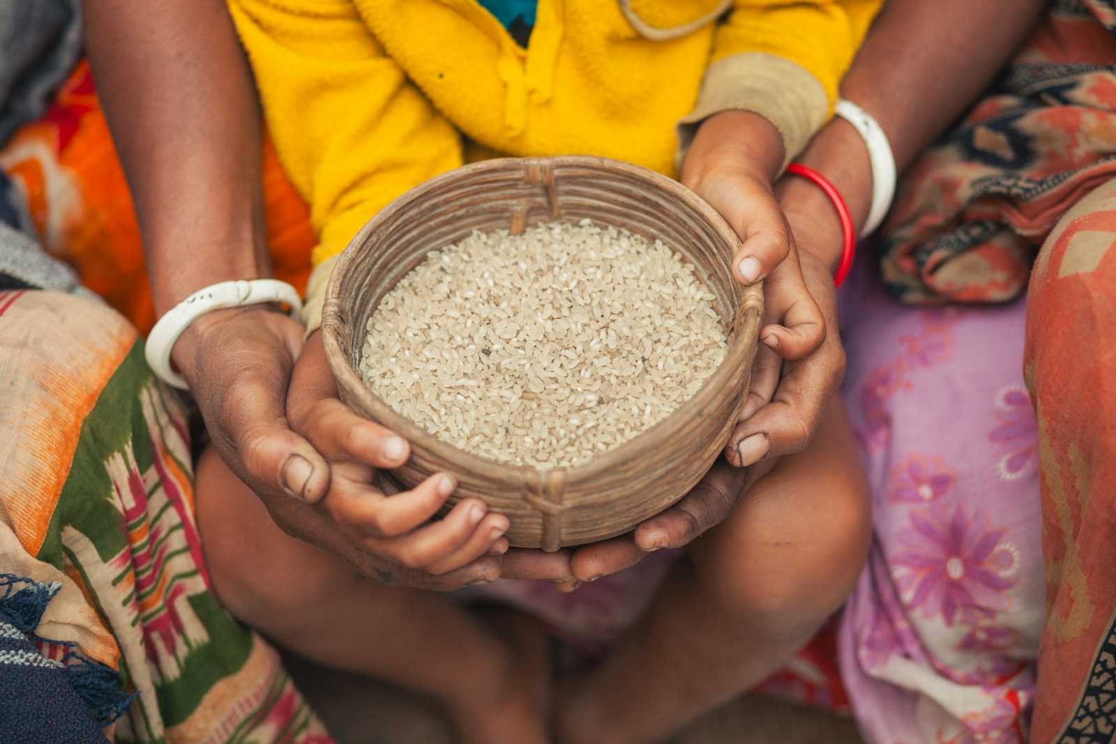 Hands holding a bowl of rice