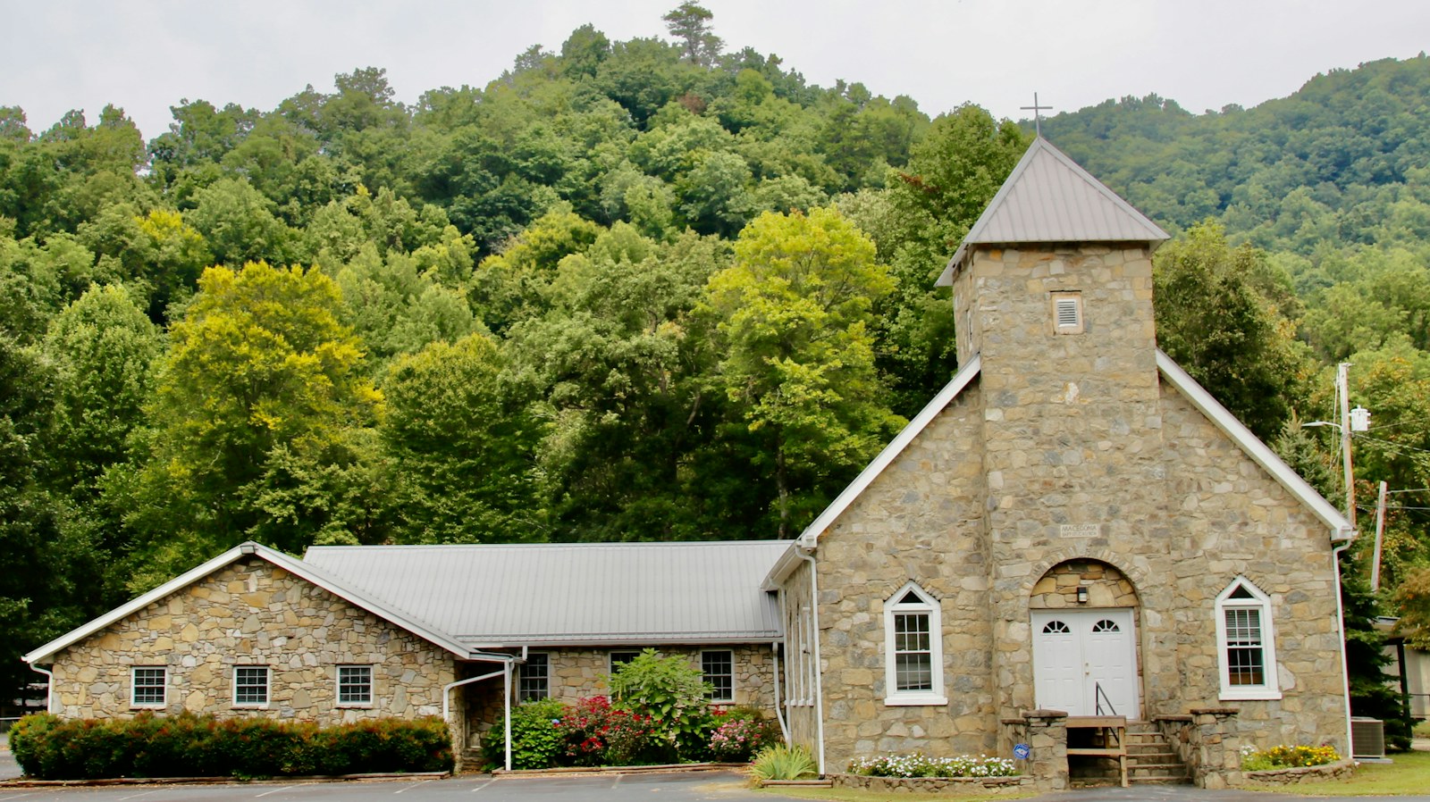 a church with a steeple surrounded by trees
