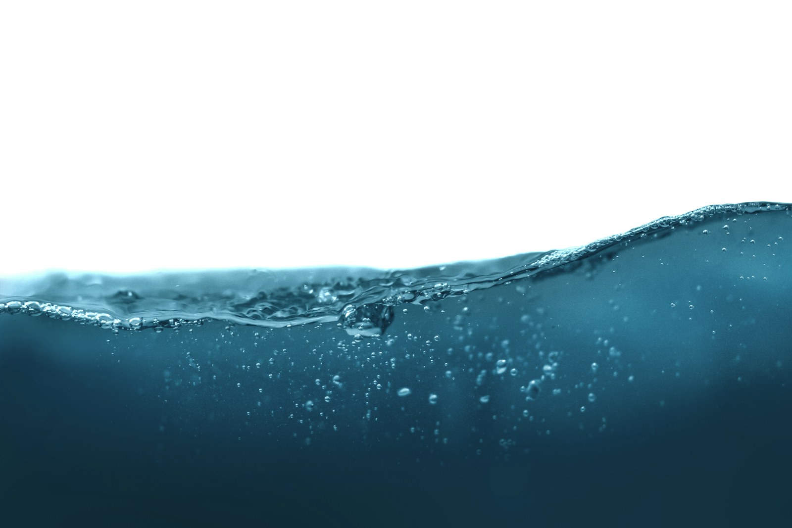 A dark blue water wave with small bubbles against a white background