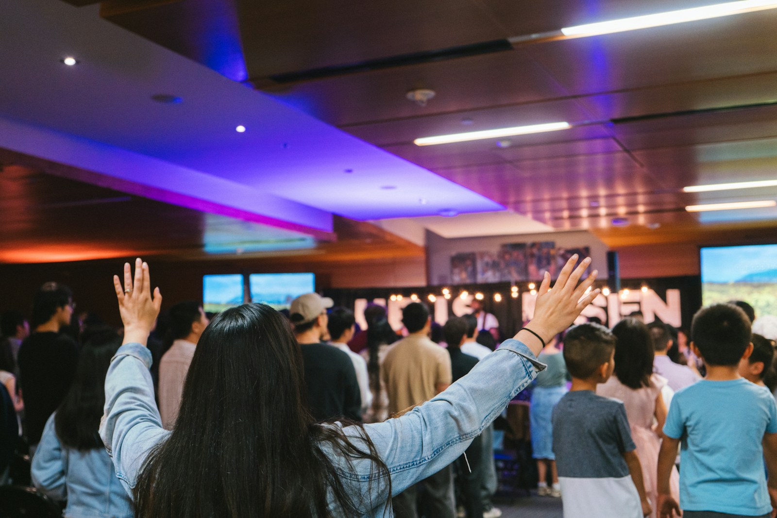 People raise their hands during a worship service