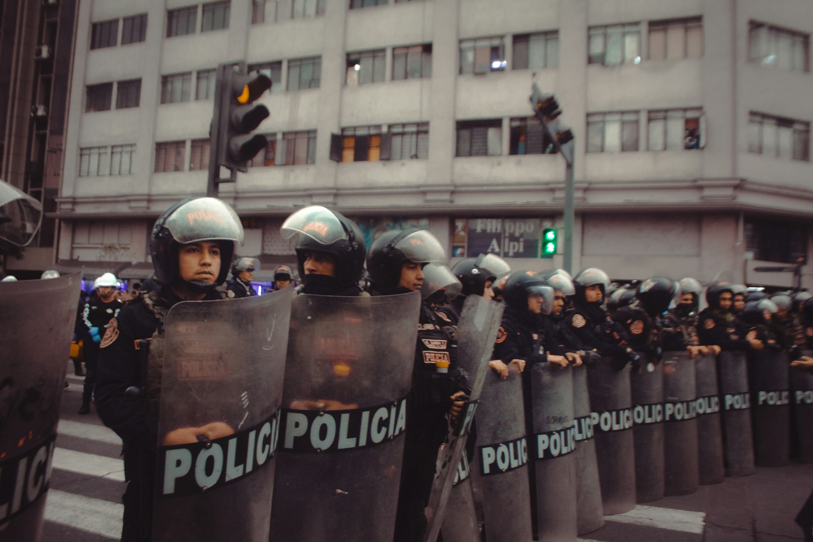 Police officers in riot gear stand in formation