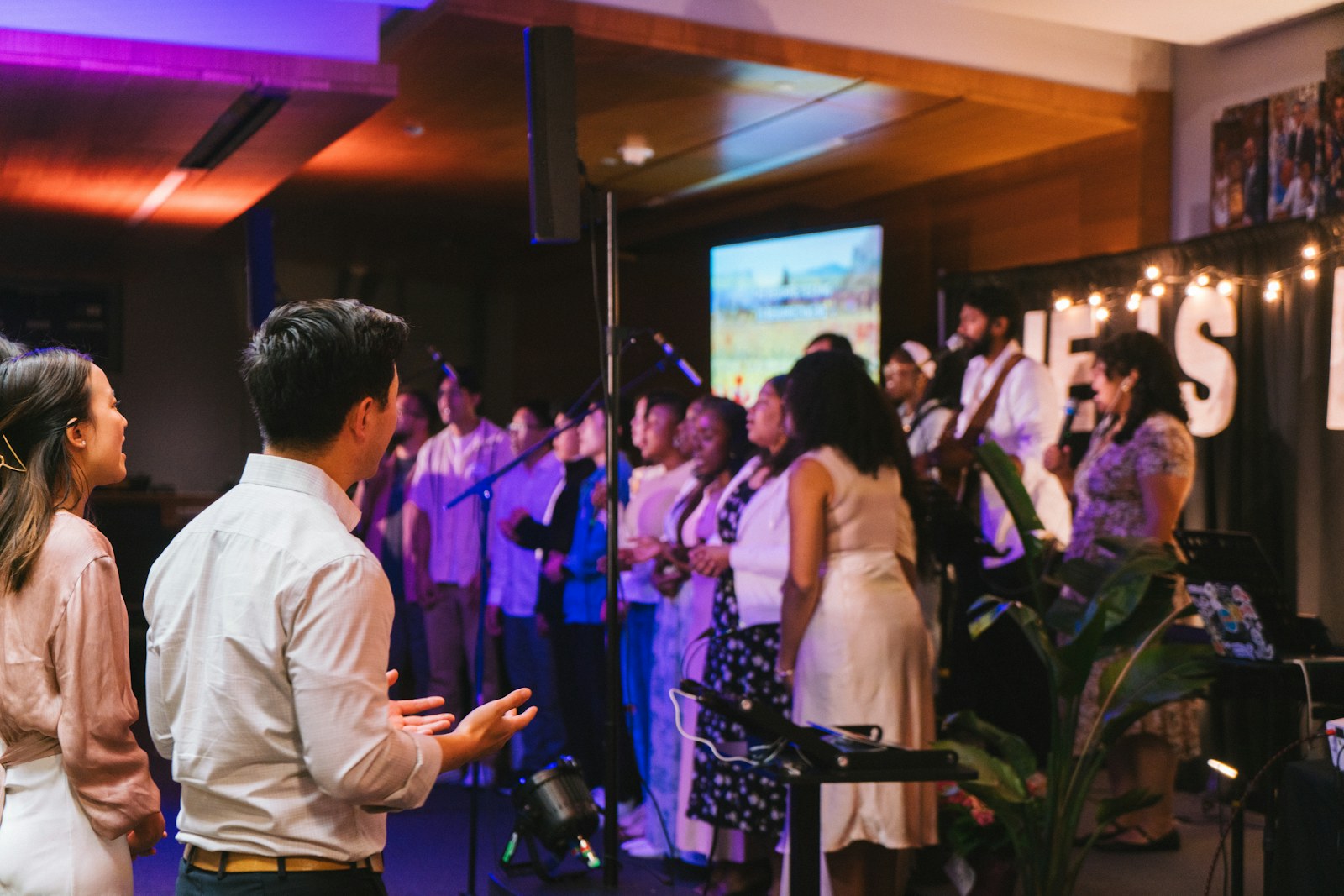 A choir performs on stage in front of an audience