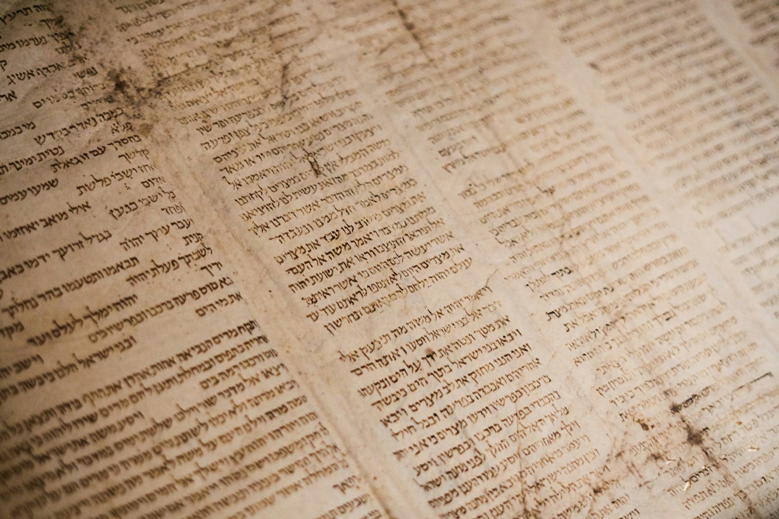 Ancient Hebrew text written on weathered parchment with visible stains and texture