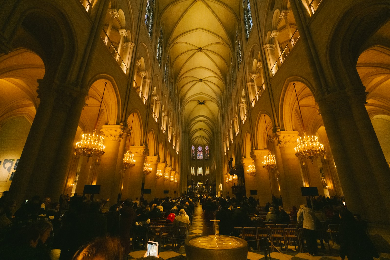 Warmly lit cathedral interior with a large congregation