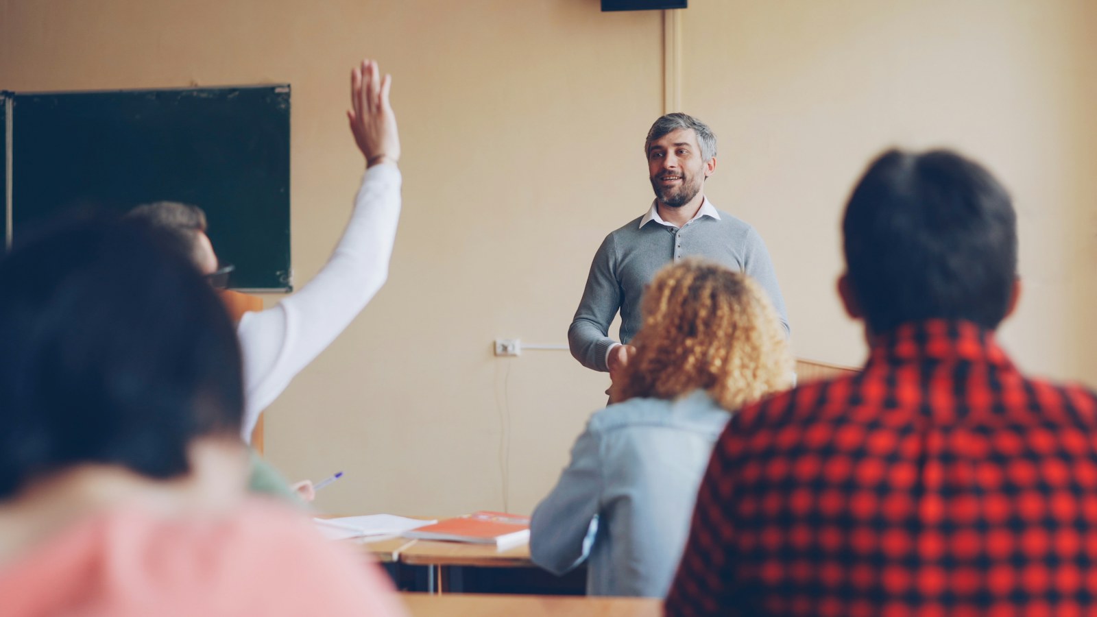 Teacher asking a question to students in a classroom