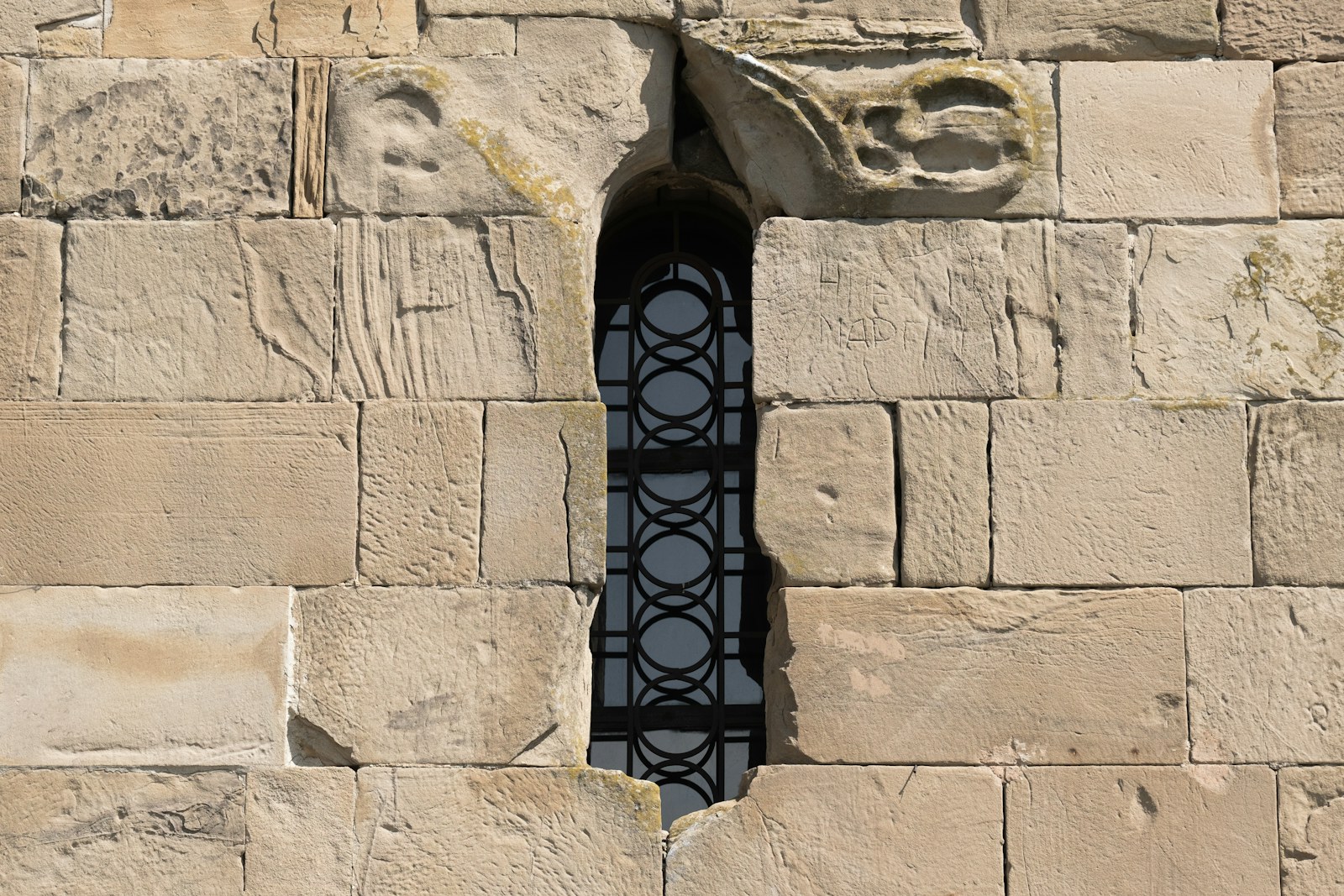 A window in a stone wall with a bird perched on it