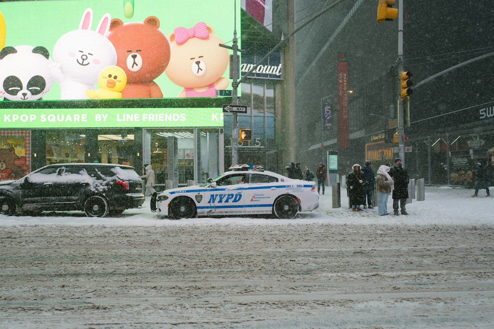 Nypd car on a snowy city street with billboards