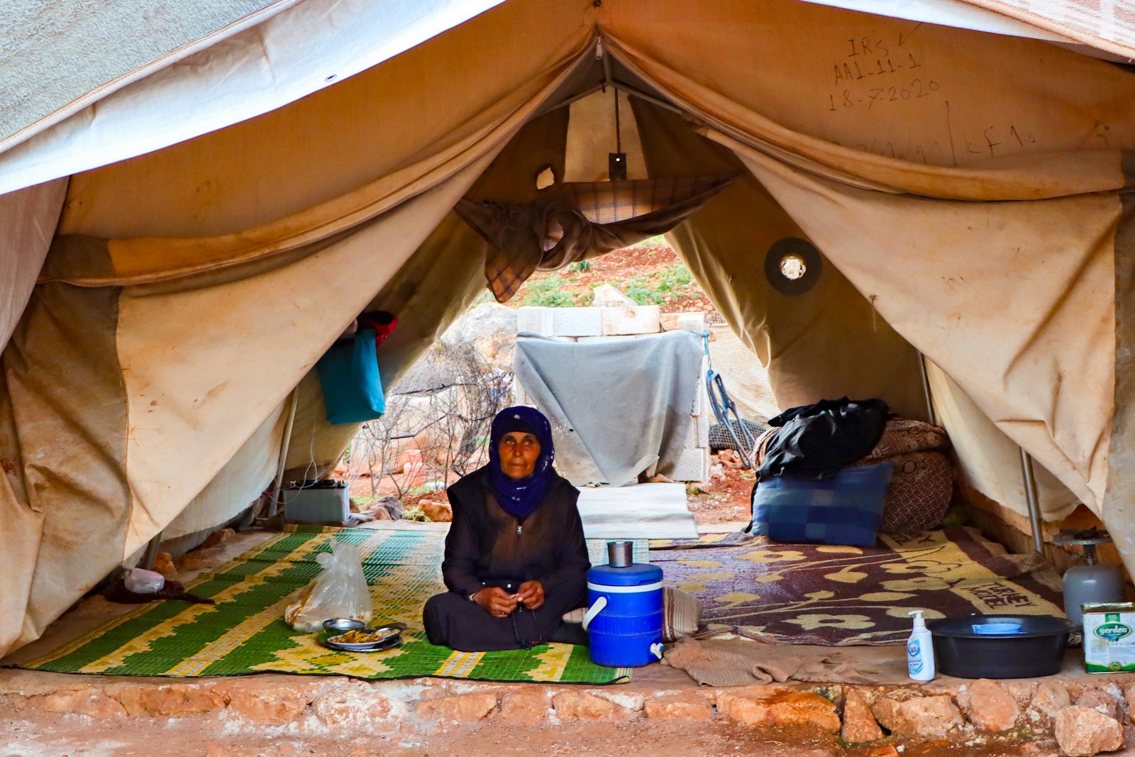A person sitting on a rug in a tent
