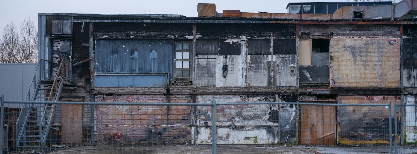 A run down building with a fire hydrant in front of it