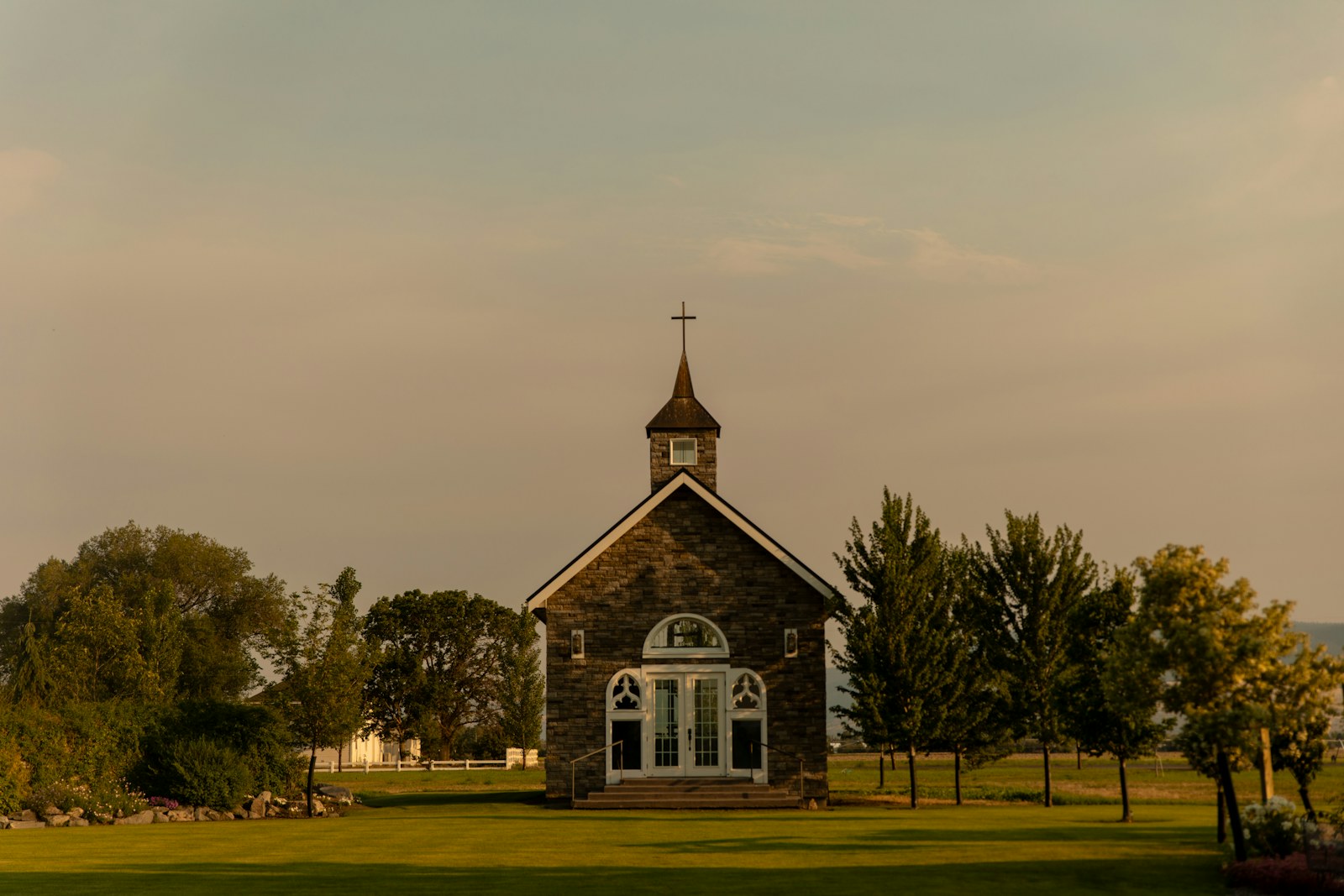 A small church sits amidst trees and greenery