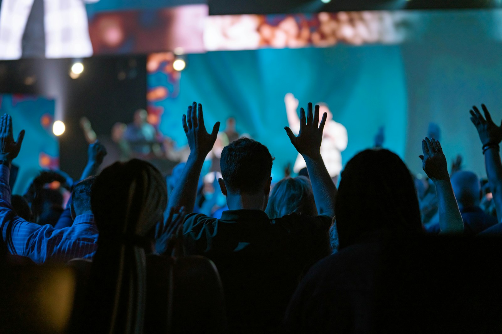 a crowd of people with their hands up in the air