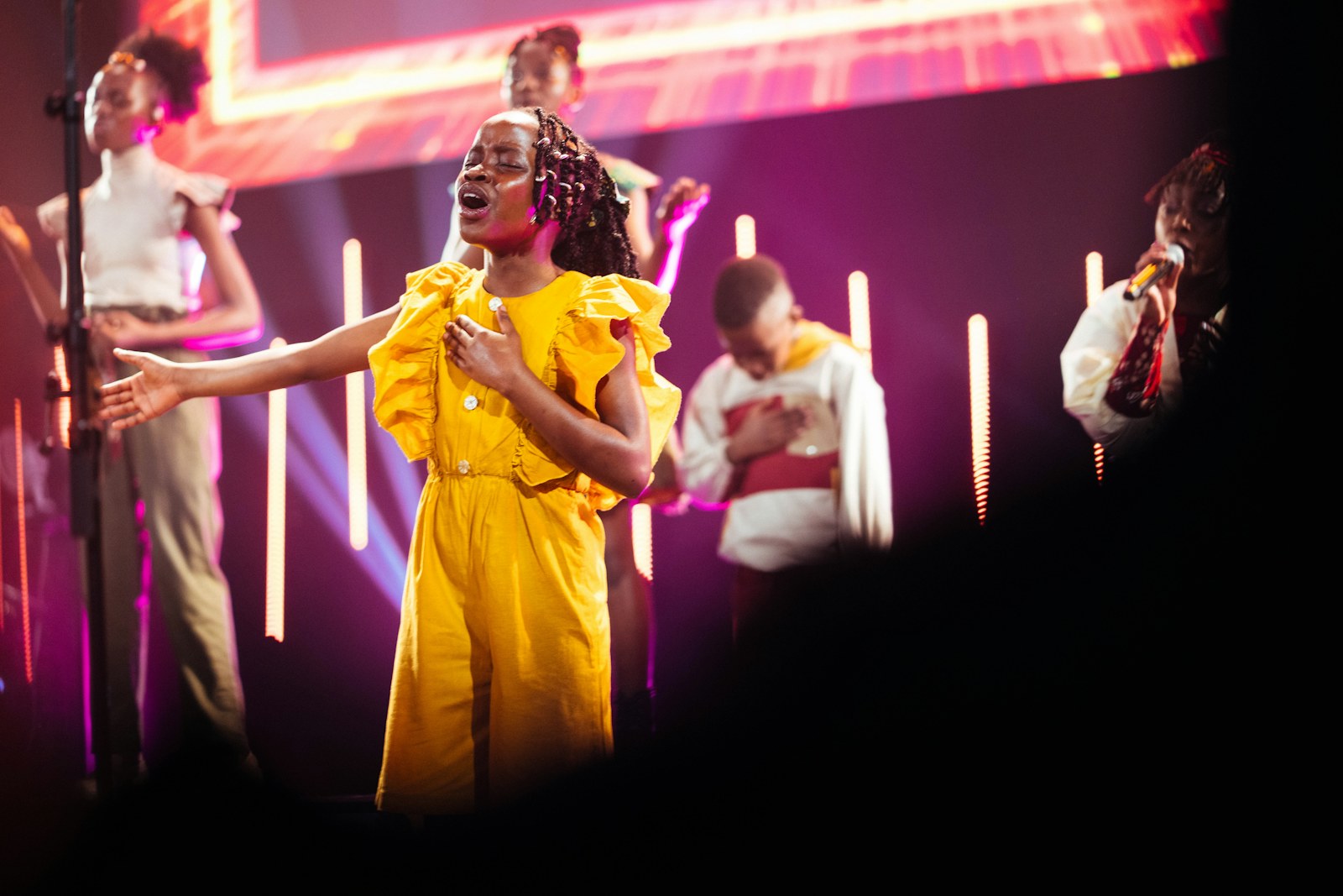 Children sing together on stage