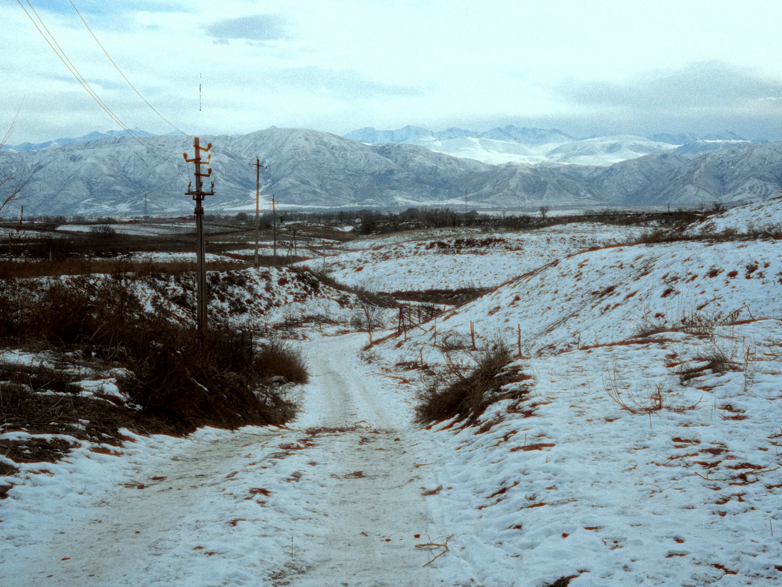 Snowy mountain landscape with a dirt road