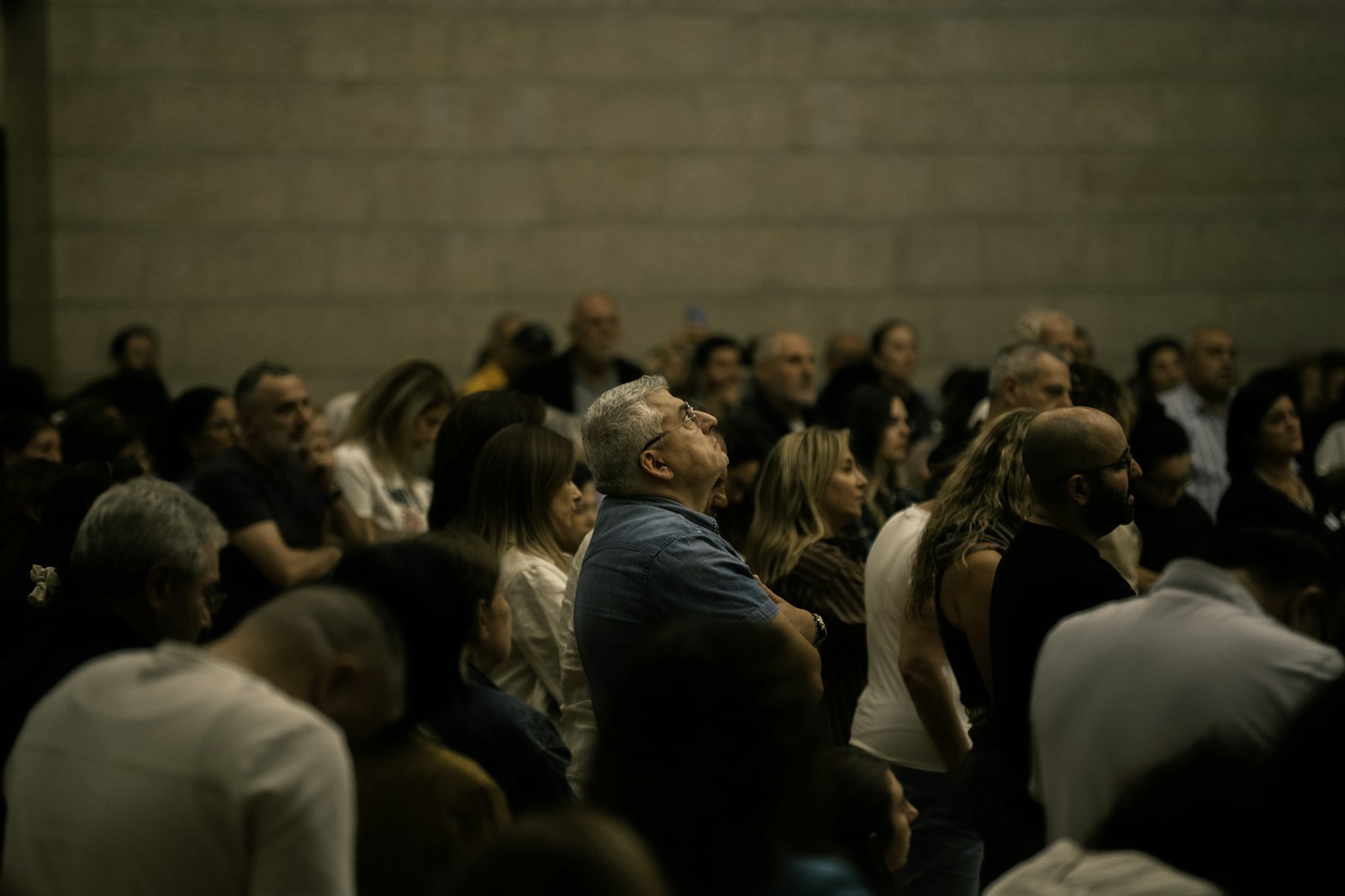A diverse crowd of people looking upwards