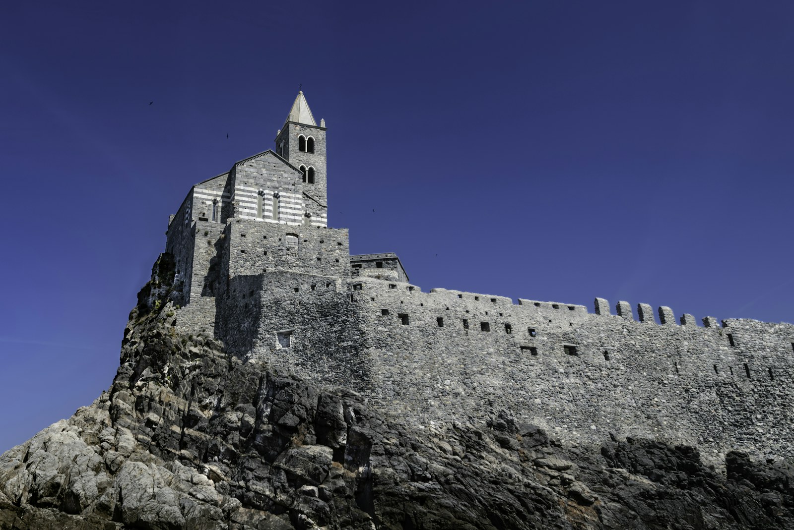 Historic stone church and wall on a rugged cliff