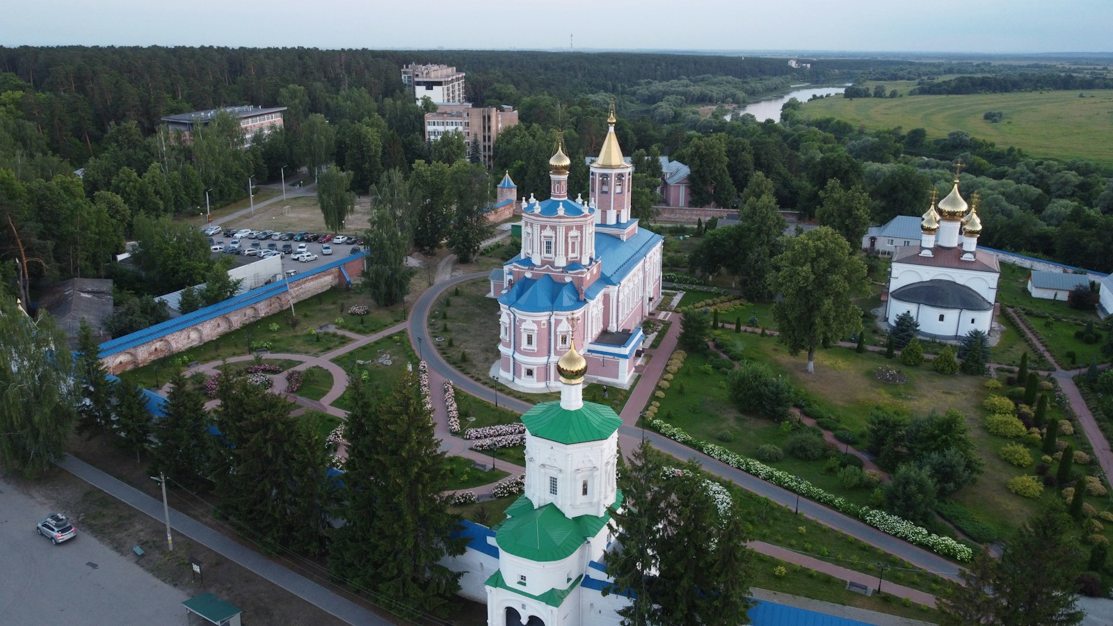 an aerial view of a church surrounded by trees