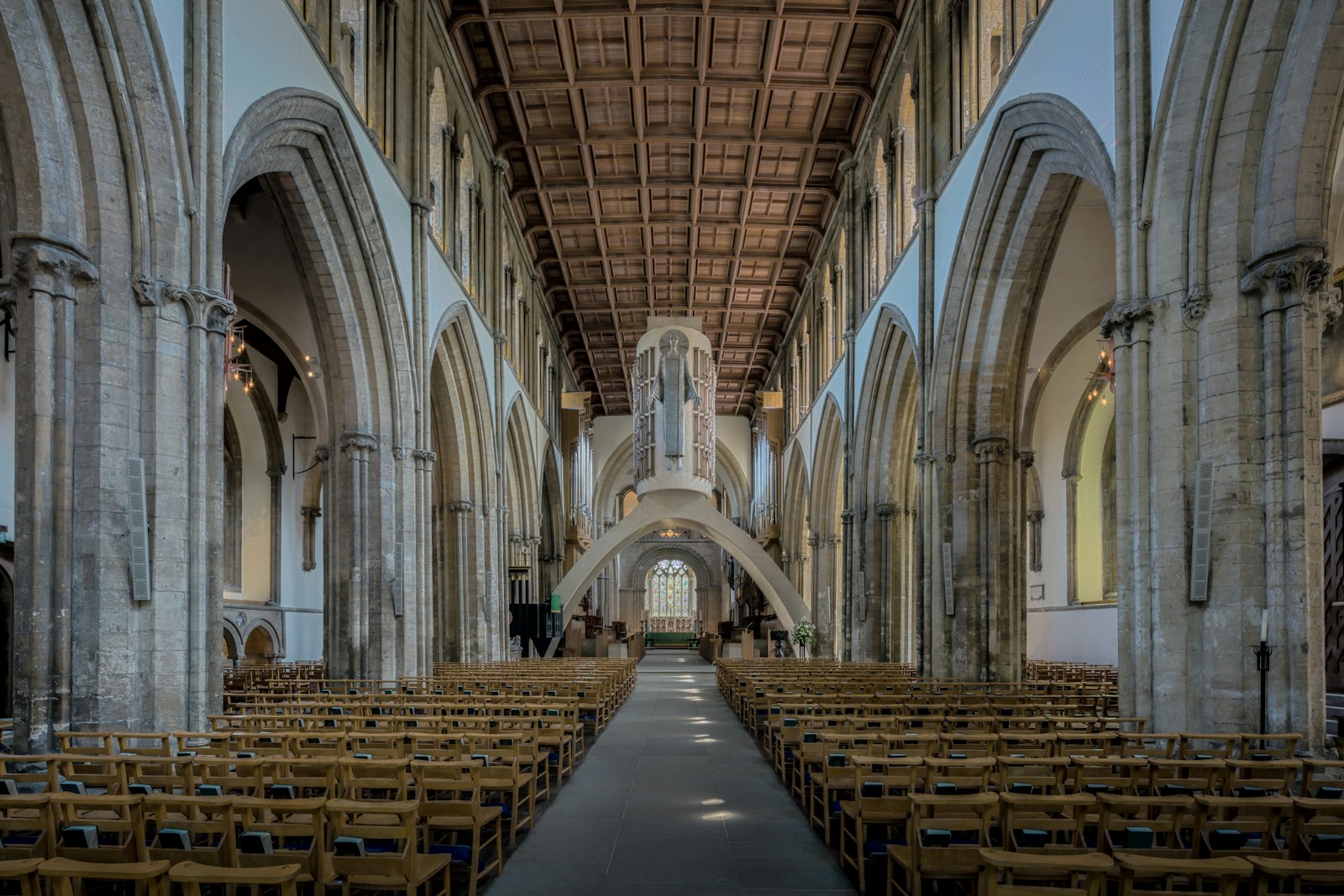Rows of chairs inside a grand church with stone arches