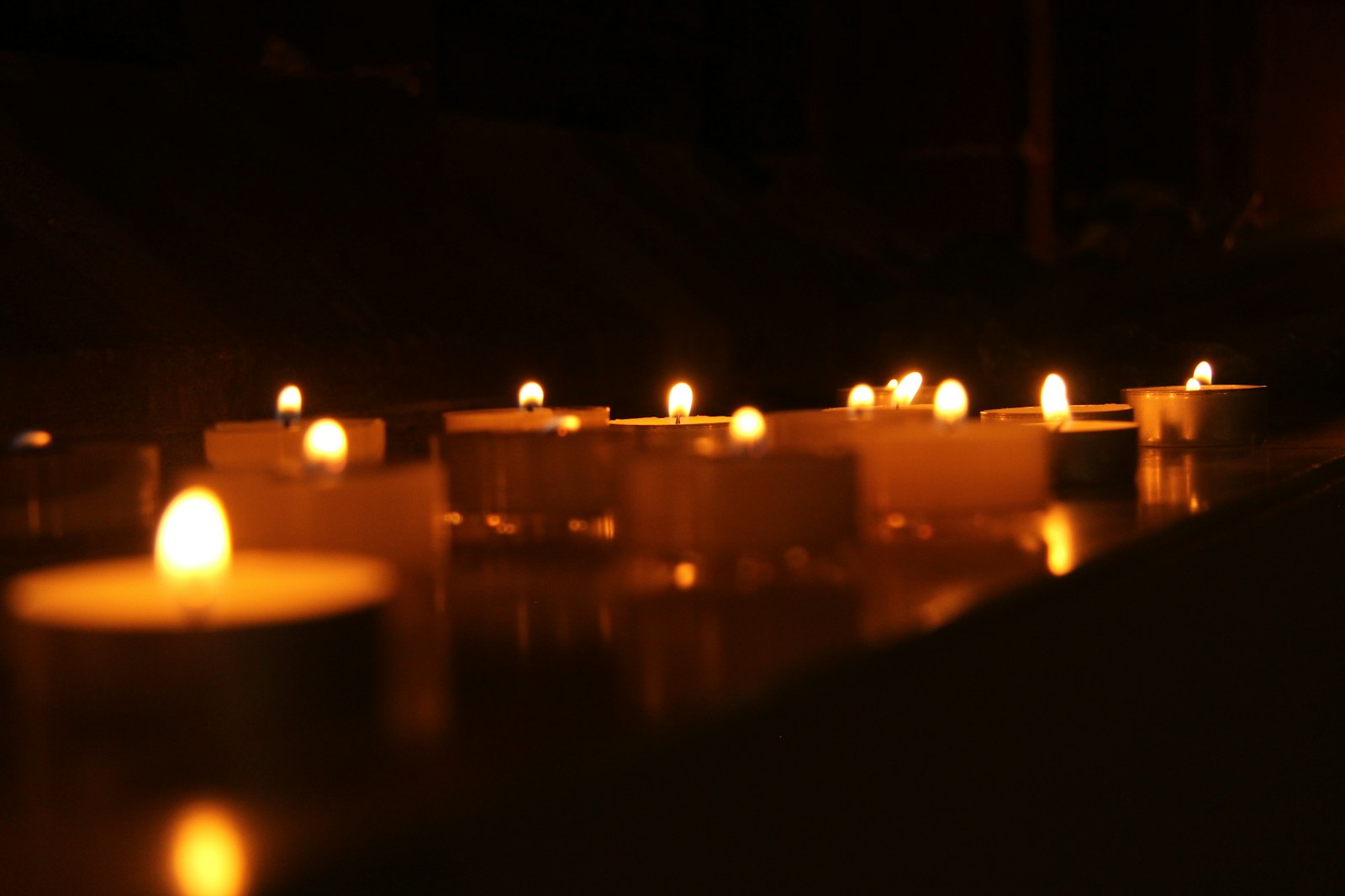 Lit candles illuminate a dark room