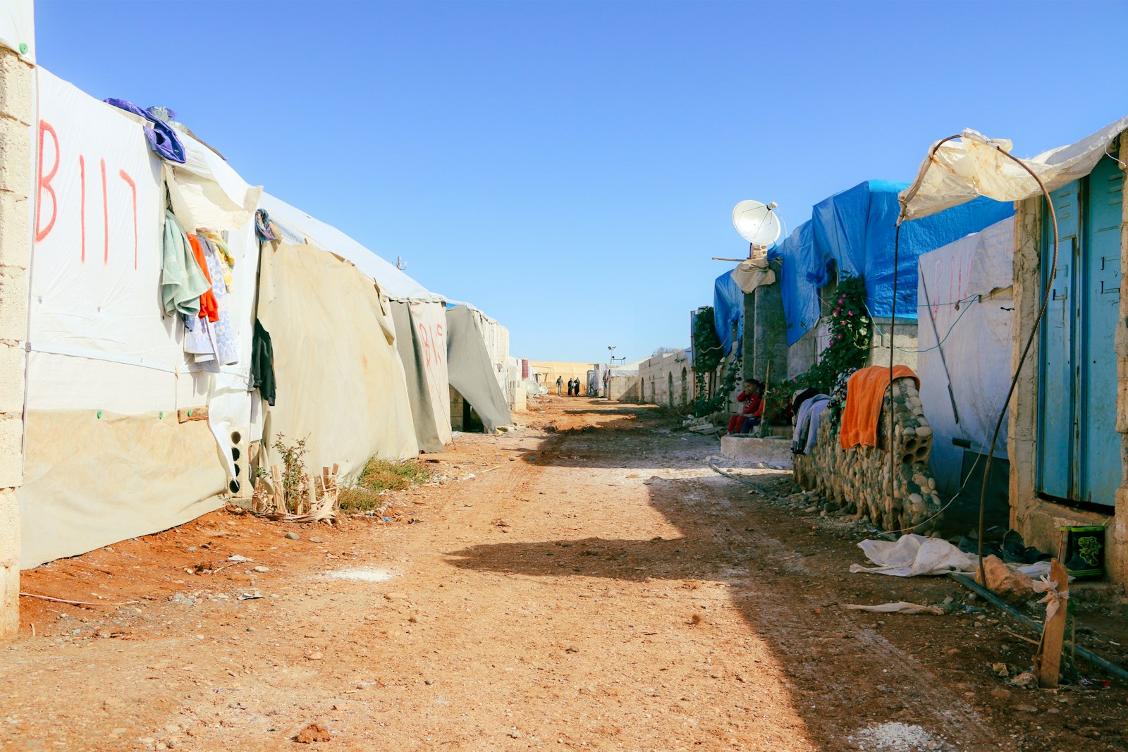 A dirt road lined with tents and shacks