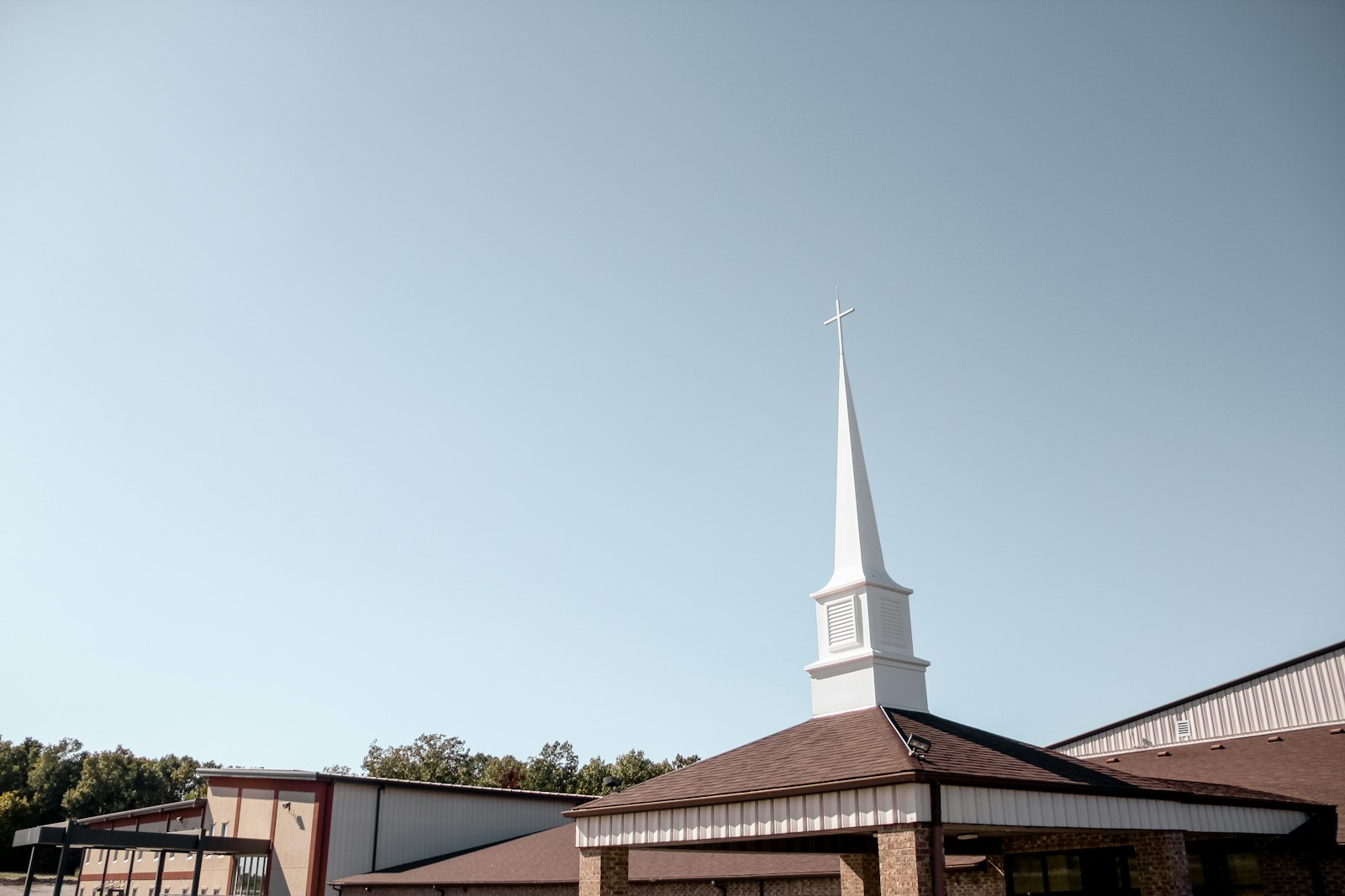 A church with a white steeple on a clear day