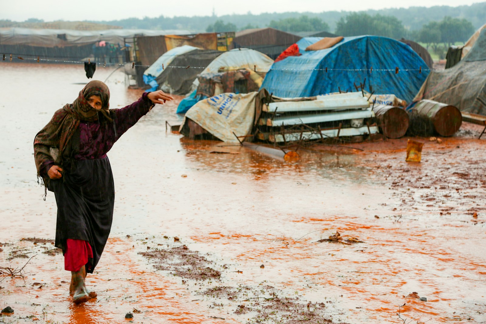A woman is walking through a flooded area