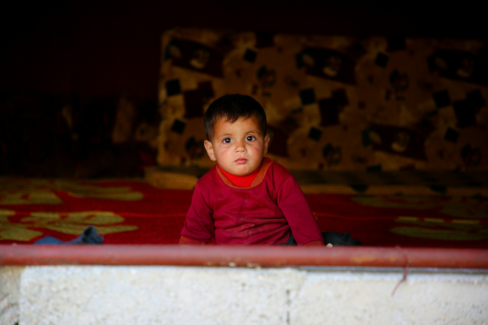 A little boy sitting on top of a bed
