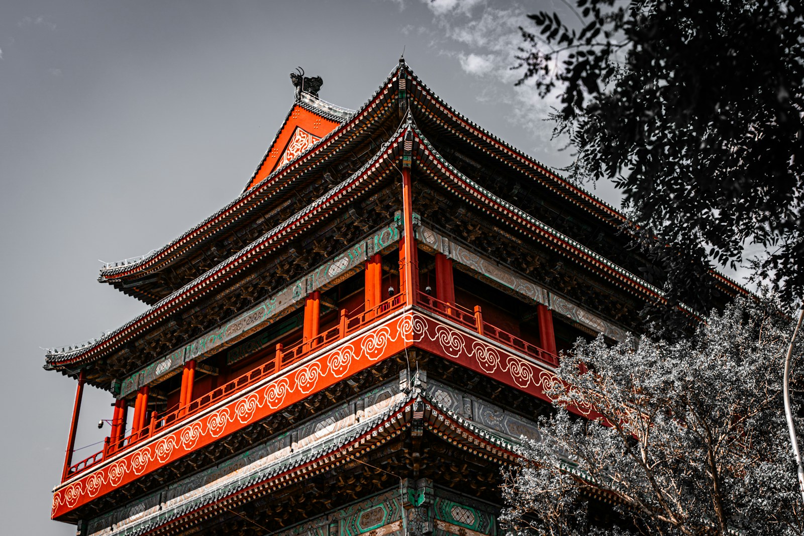 A tall building with a red roof next to trees