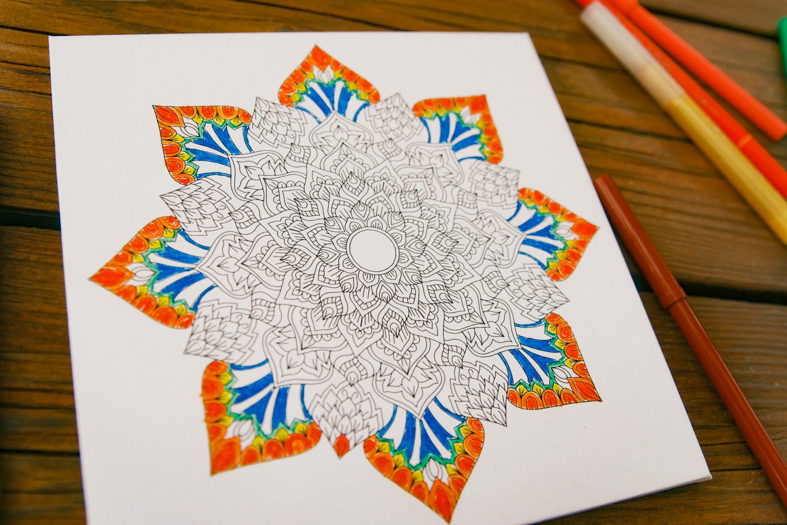 Mandala coloring page with orange and blue details