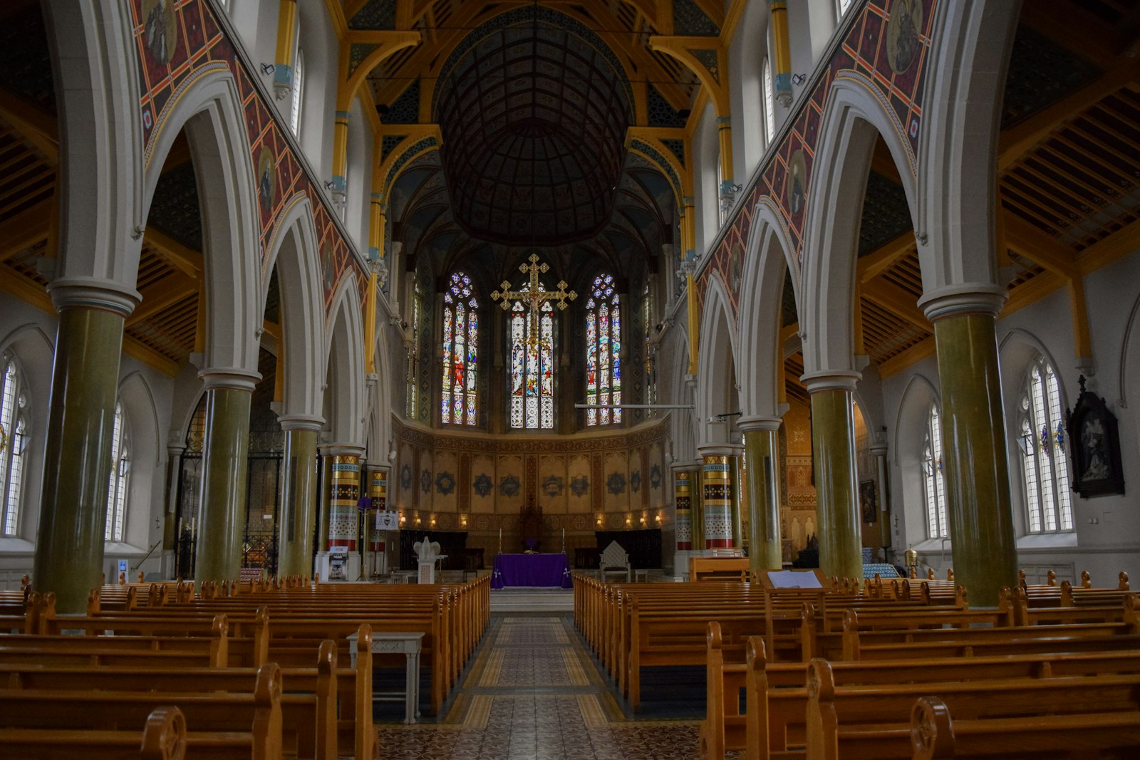 Interior view of a grand church with wooden pews