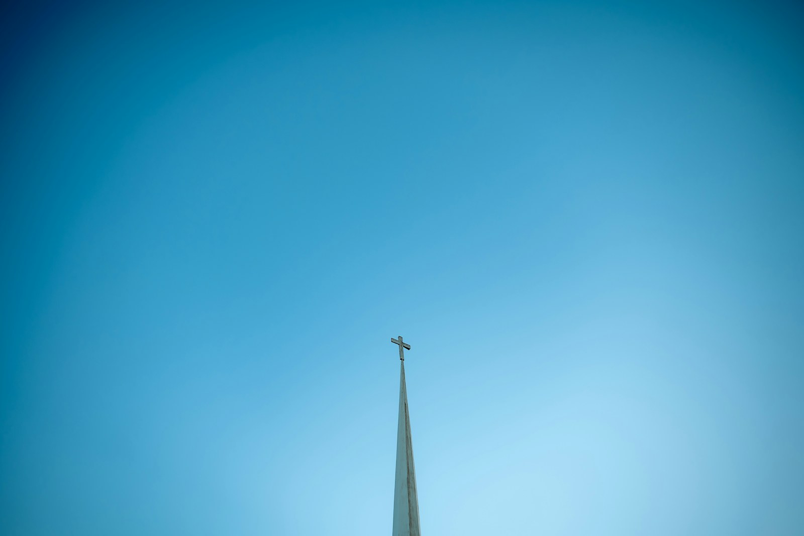 Church steeple with cross against a clear blue sky