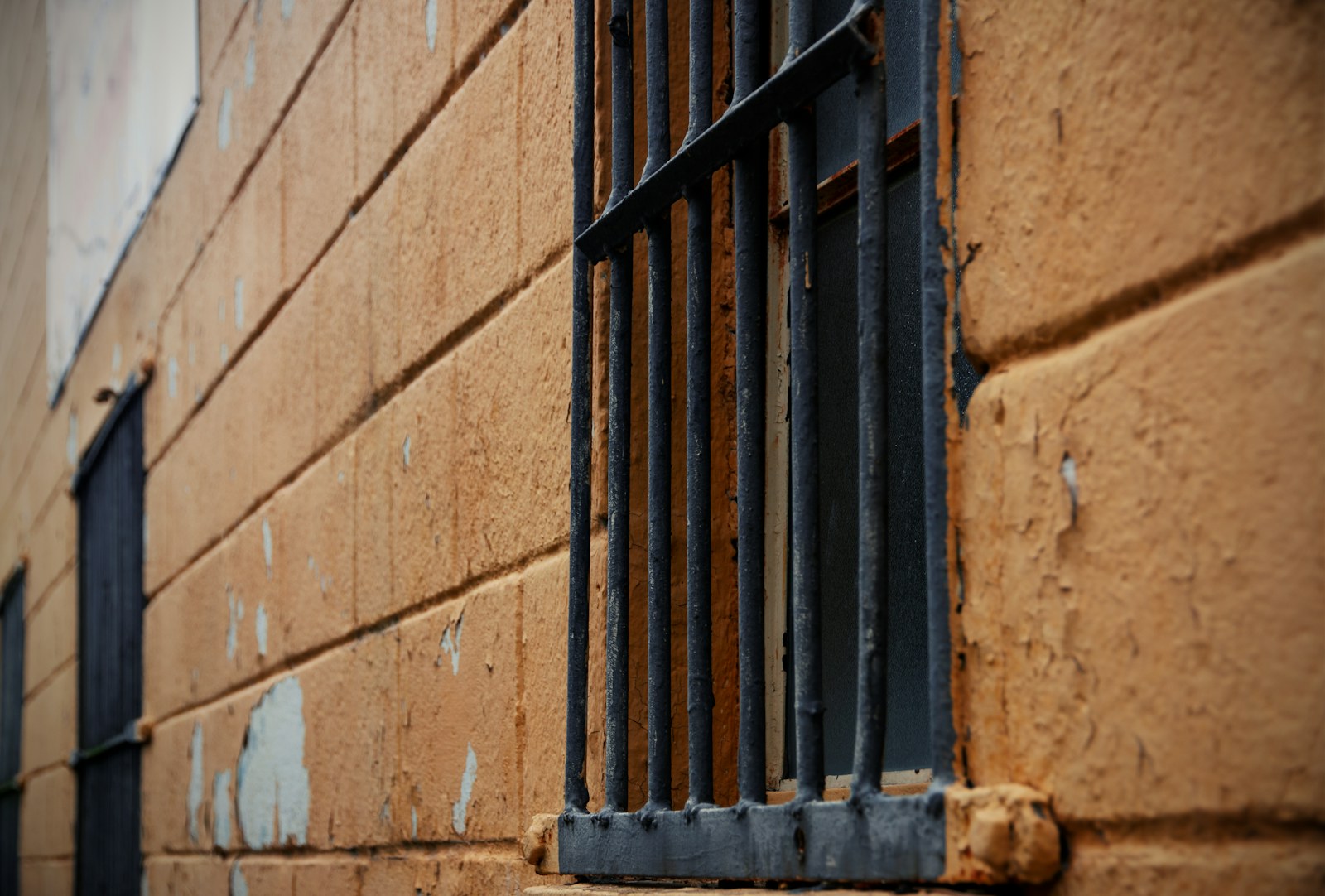 a close up of a barred window on a brick wall