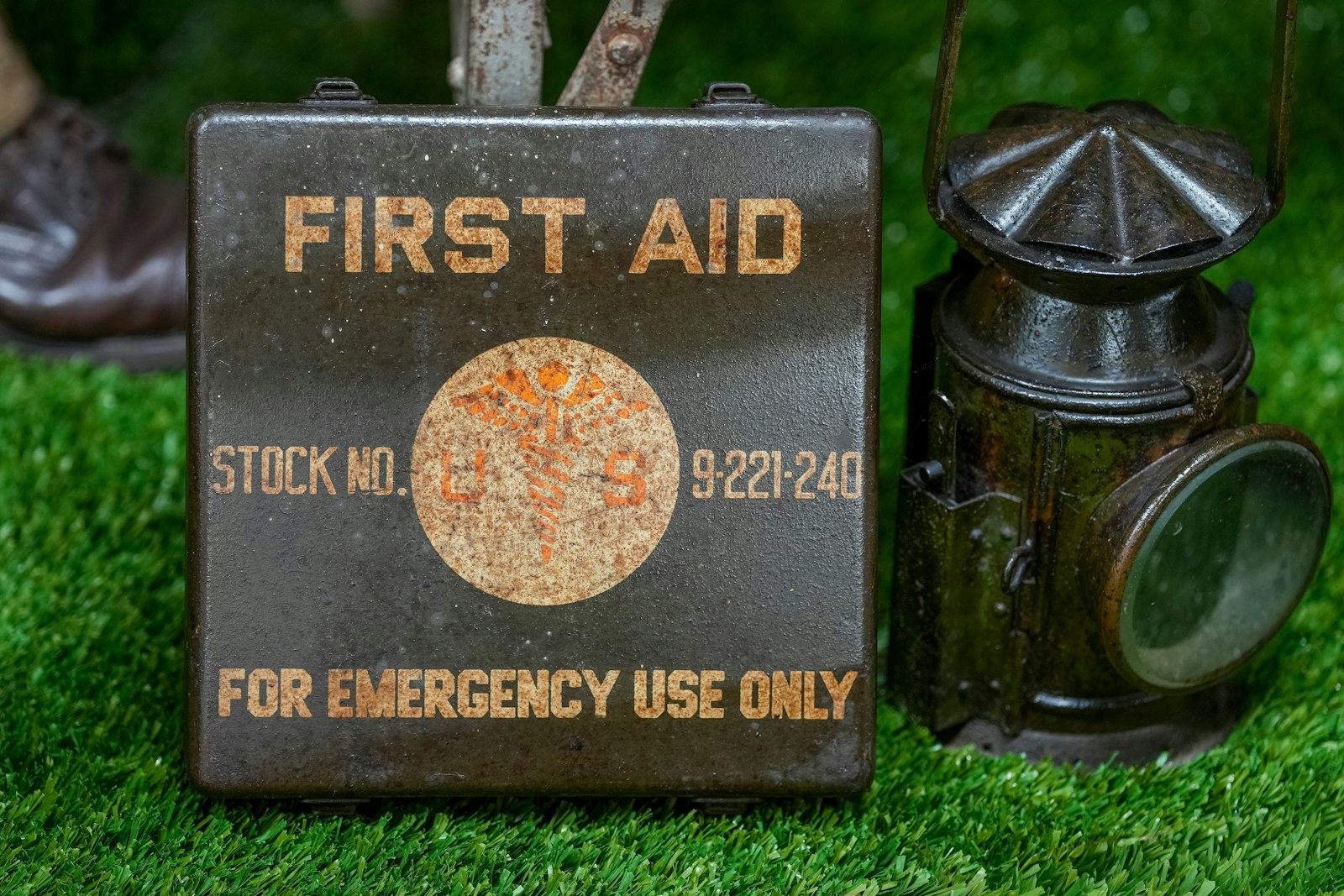 Vintage first aid kit and lantern on grass