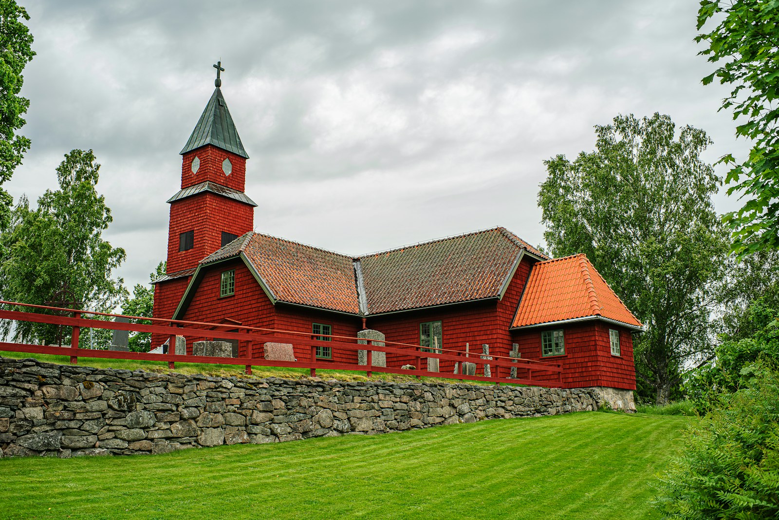 Historic red wooden church on a green hill