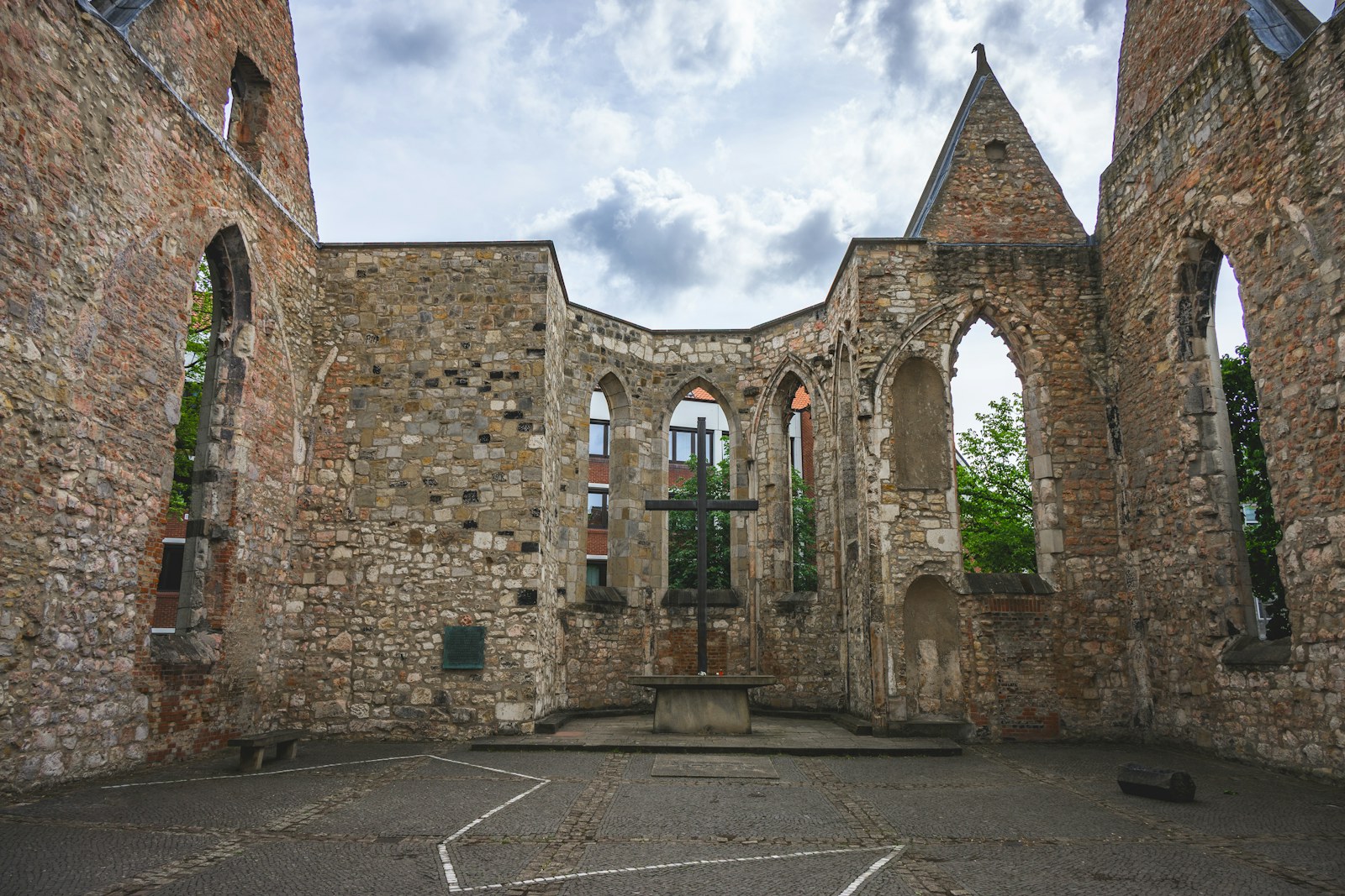 Interior of ancient stone church ruins with a metal cross