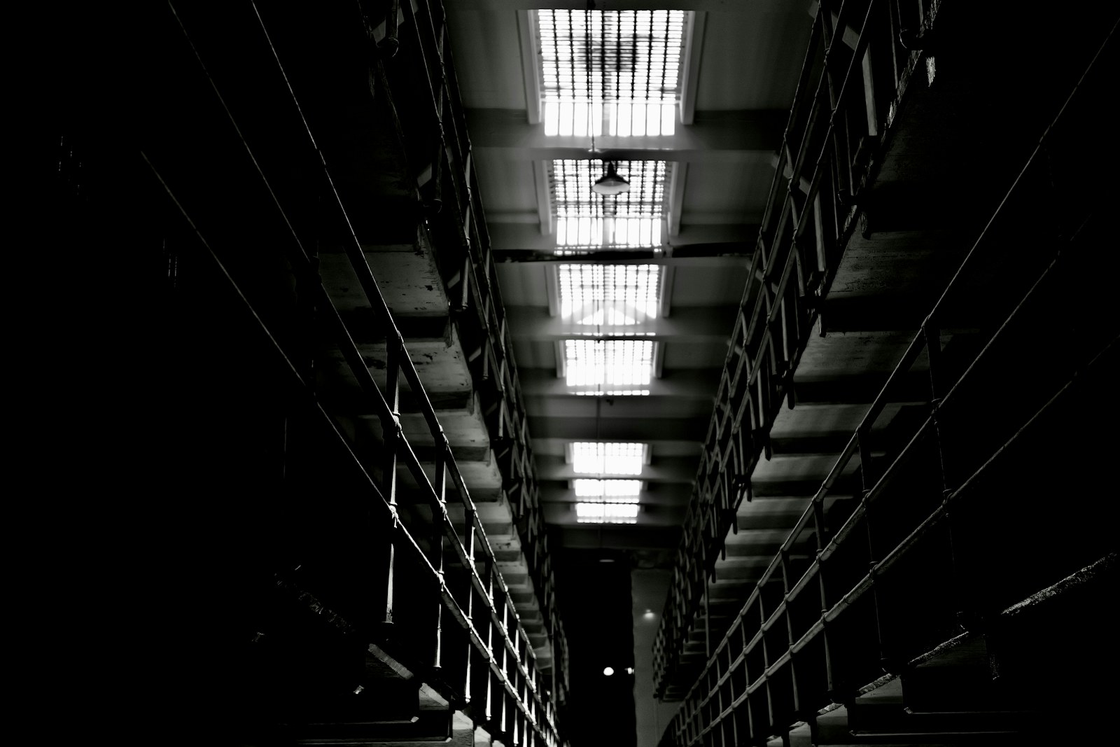 Dark, narrow hallway with bright, barred skylights
