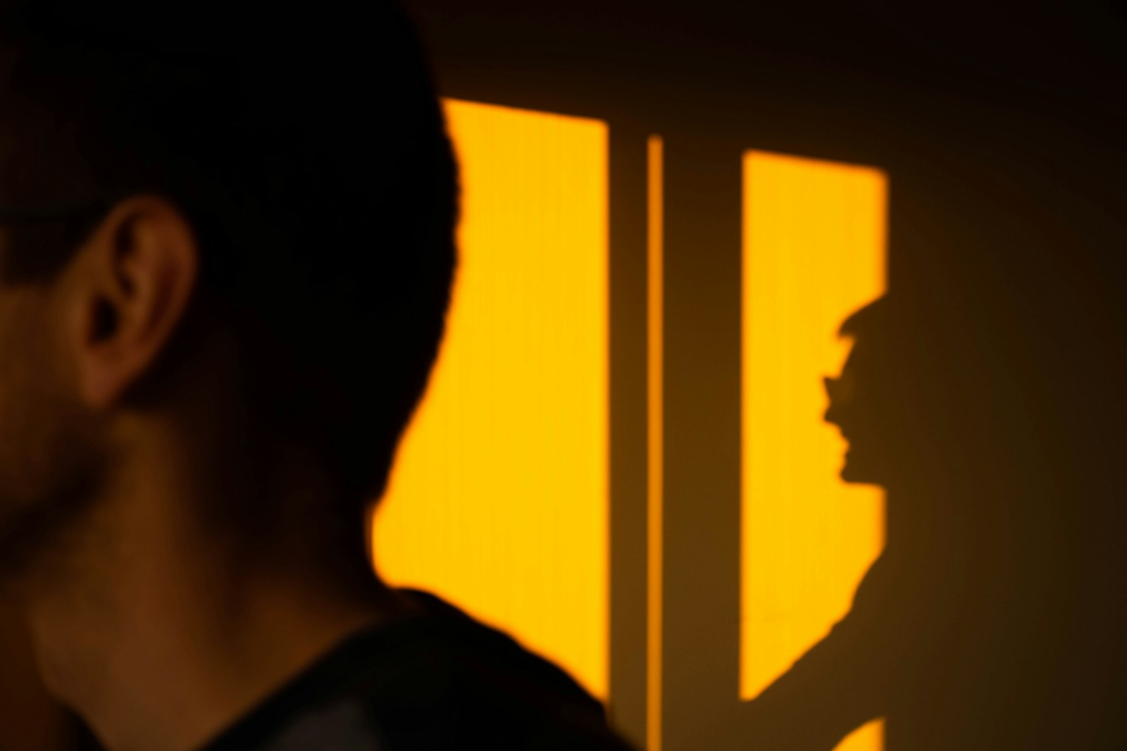 woman in black shirt standing near yellow wall