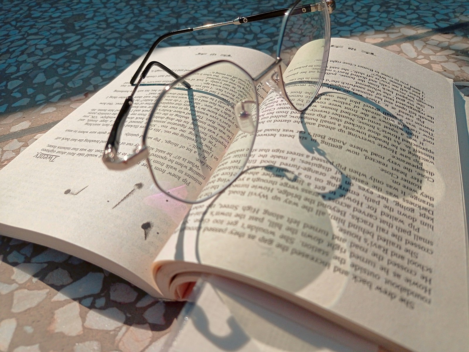 an open book with glasses on top of it