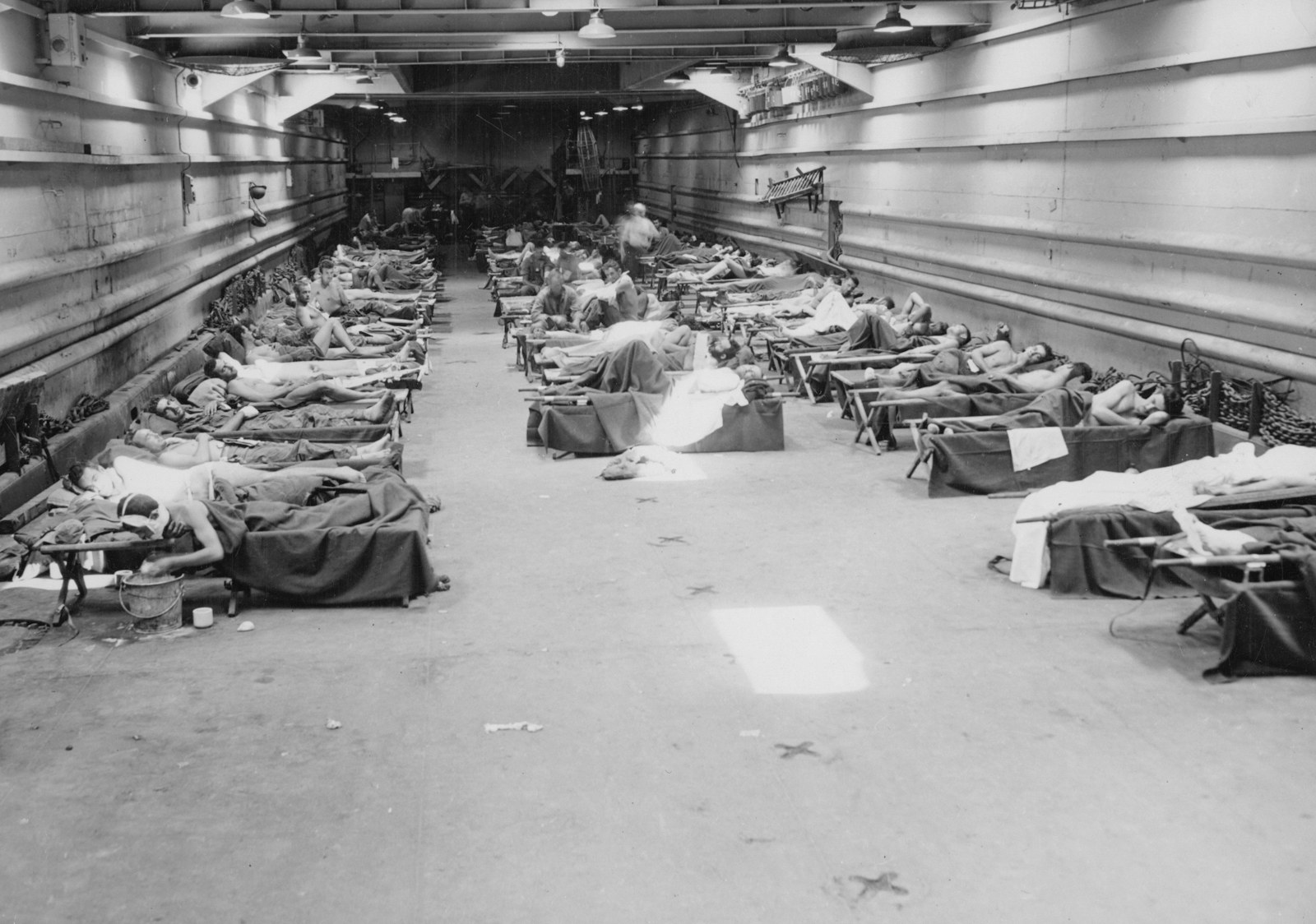 Rows of beds filled with patients in a large hall