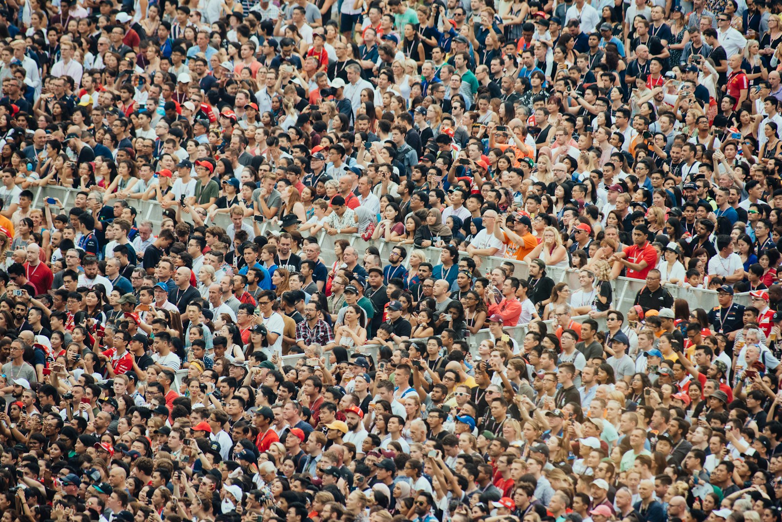 A large crowd of people watching an event from stadium seating