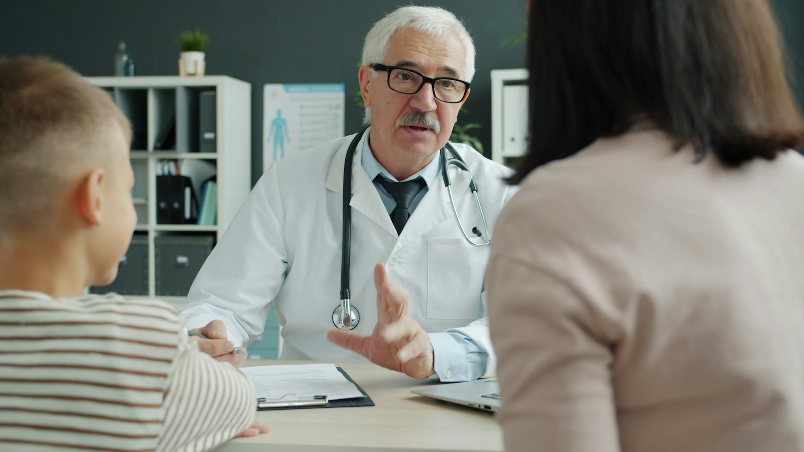 Doctor consults with mother and child in office