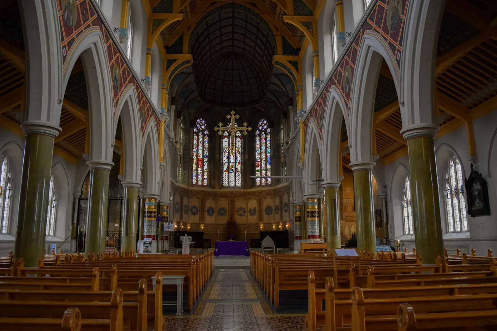 Interior view of a grand church with wooden pews