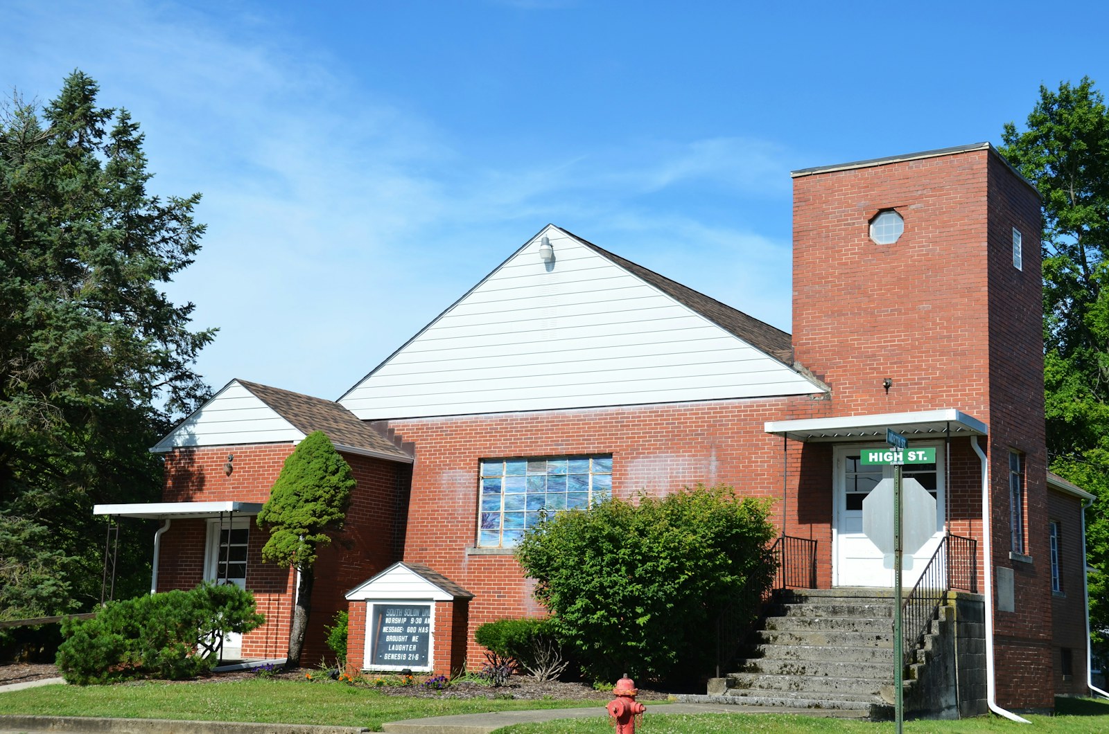 Red brick church building under a clear blue sky